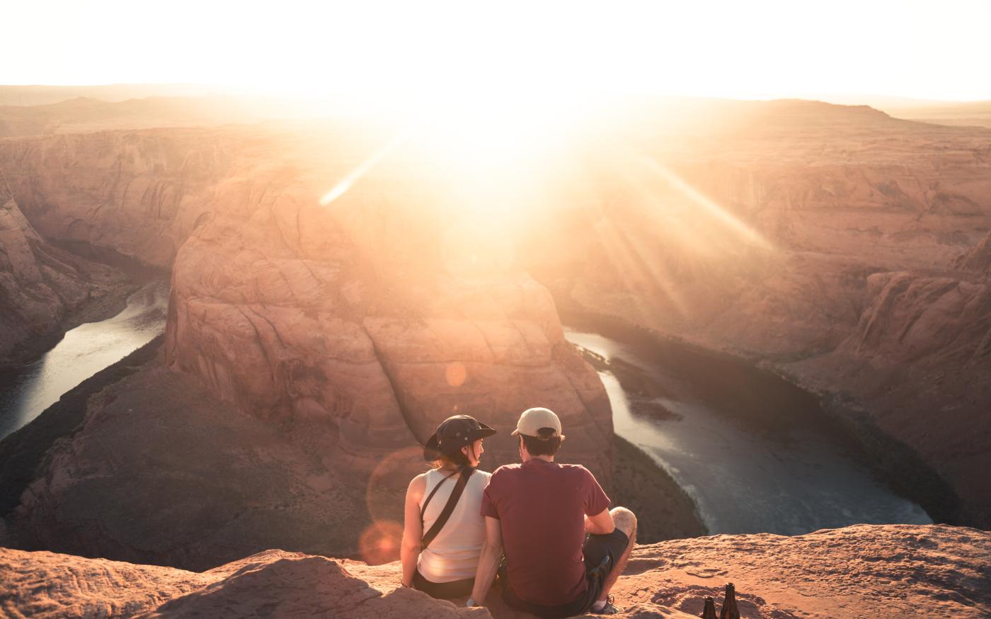man and woman sitting on rock formation by Christopher Burns courtesy of Unsplash.