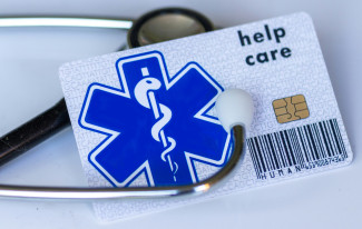 A medical card with a stethoscope on top of it by Marek Studzinski courtesy of Unsplash.