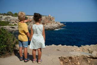 two children standing near cliff watching on ocean at daytime by Torsten Dederichs courtesy of Unsplash.