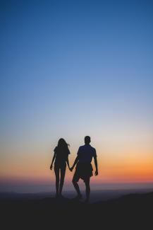 man and woman holding hands in silhouette photography by Caleb Ekeroth courtesy of Unsplash.
