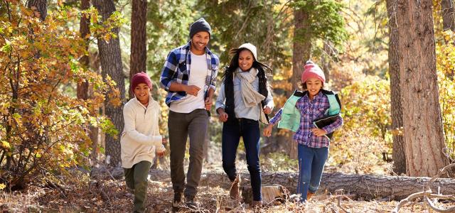 Family Walking Through Fall Woodland