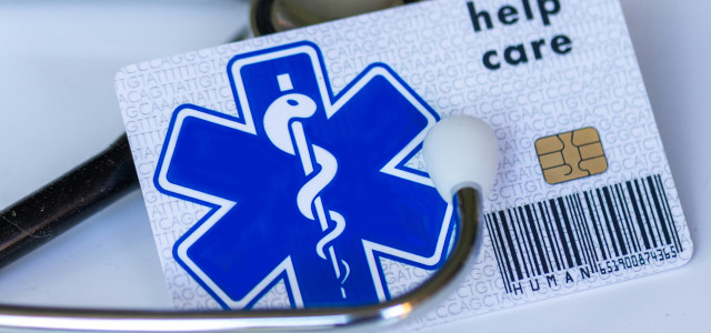 A medical card with a stethoscope on top of it by Marek Studzinski courtesy of Unsplash.