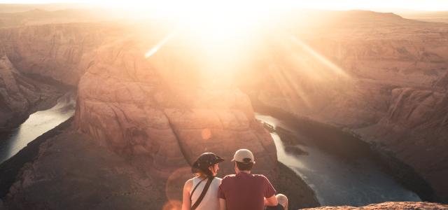 man and woman sitting on rock formation by Christopher Burns courtesy of Unsplash.